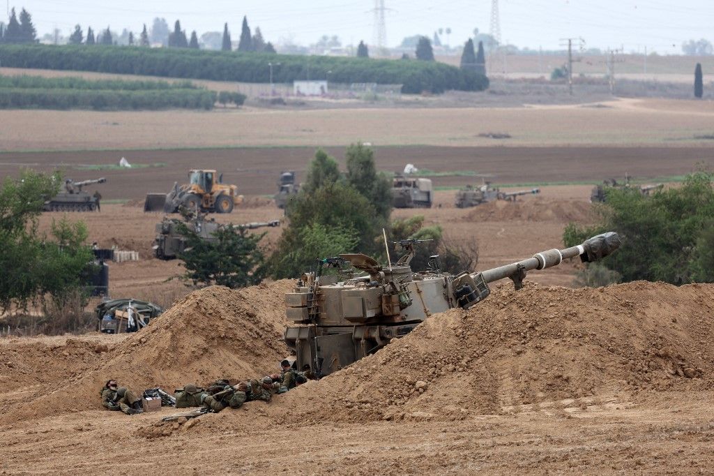 Israeli army artillary are positioned towards Gaza near the border with the Palestinian territory on October 9, 2023. Israel continued to battle Hamas fighters on October 9 and massed tens of thousands of troops and heavy armour around the Gaza Strip after vowing a massive blow over the Palestinian militants' surprise attack. (Photo by JACK GUEZ / AFP)