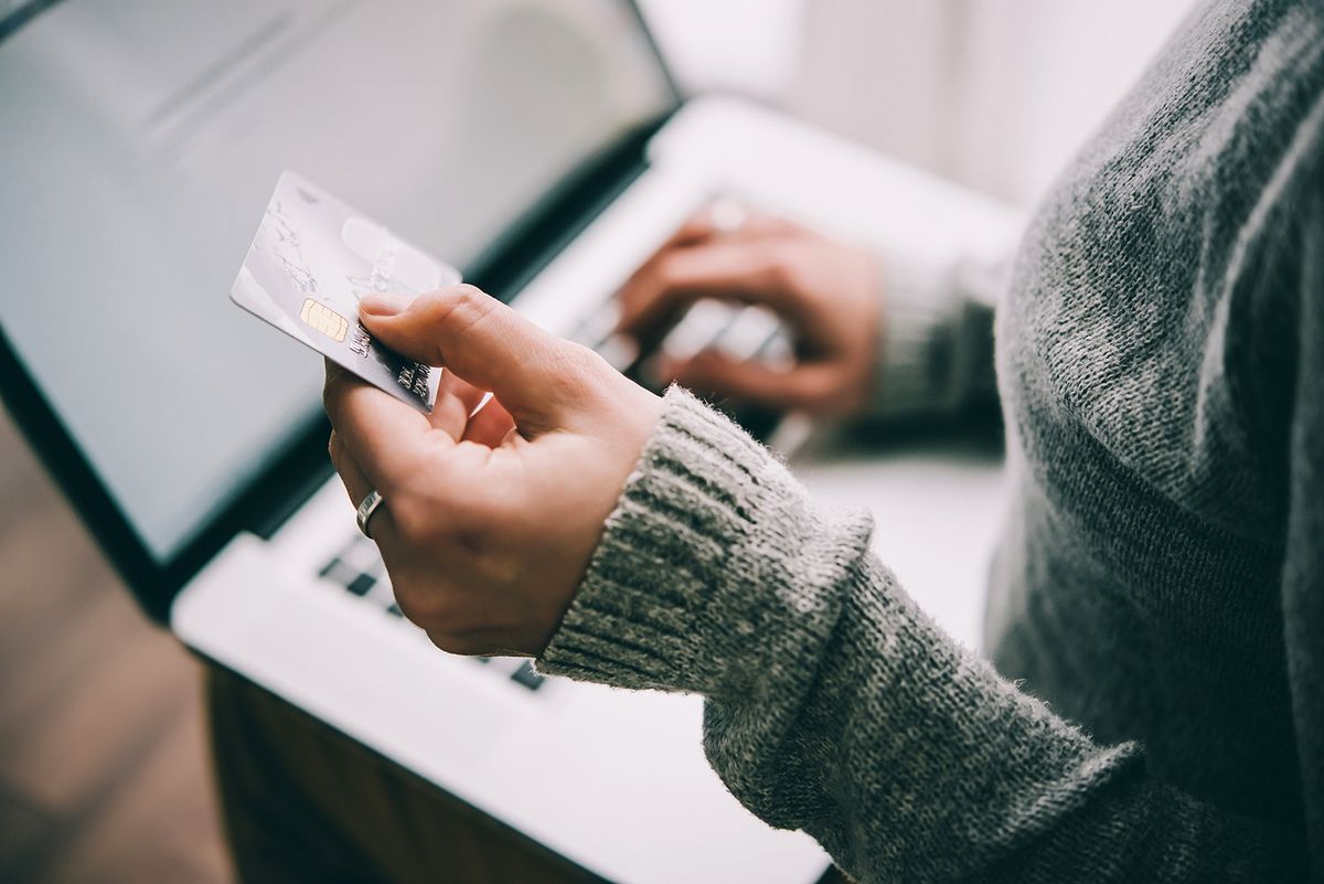 Hands,Holding,Plastic,Credit,Card,And,Using,Laptop.,Online,ShoppingHands holding plastic credit card and using laptop. Online shopping concept. Toned picture