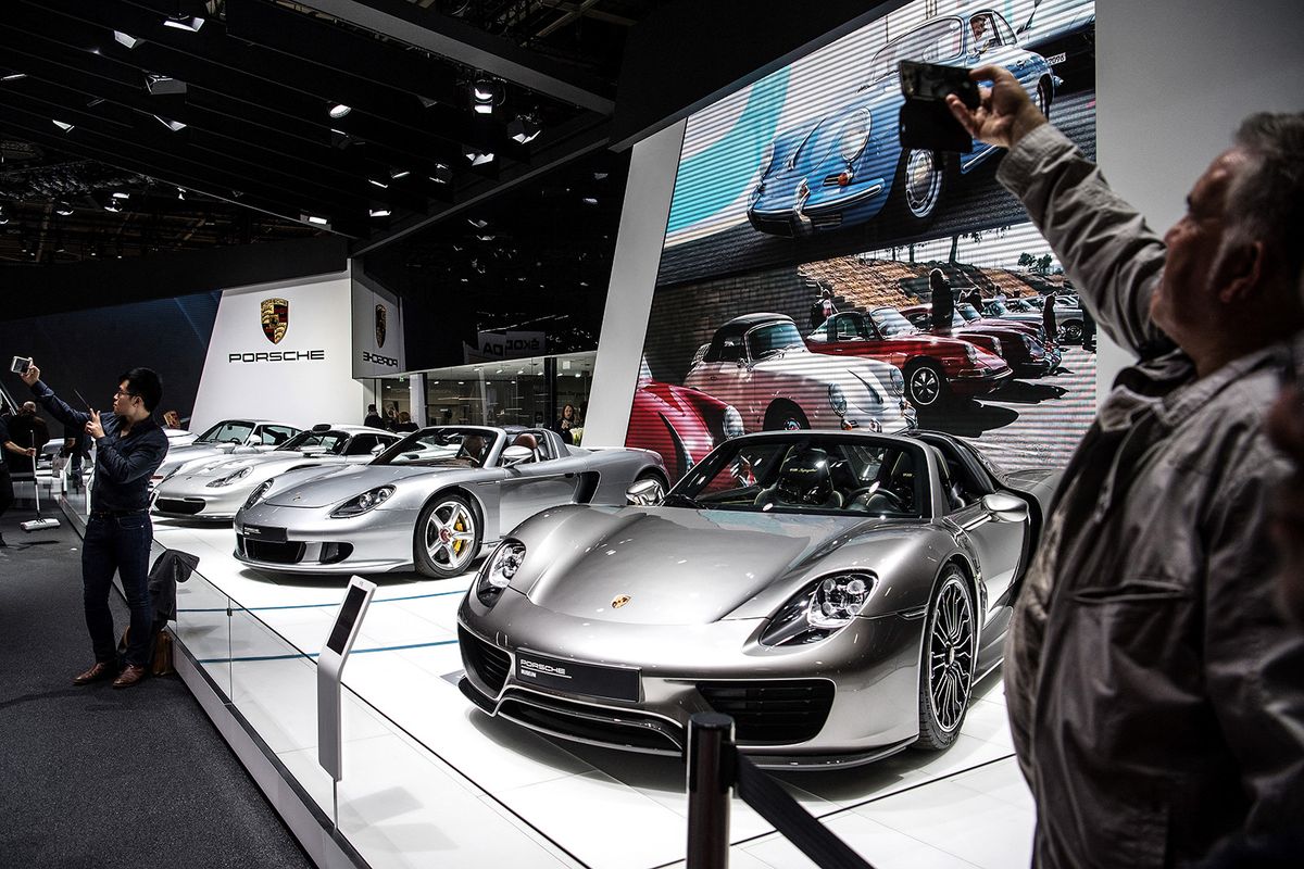 Visitors take pictures at the Porsche pavilion during the Paris Motor Show on October 4, 2018 in Paris. (Photo by Christophe ARCHAMBAULT / AFP)