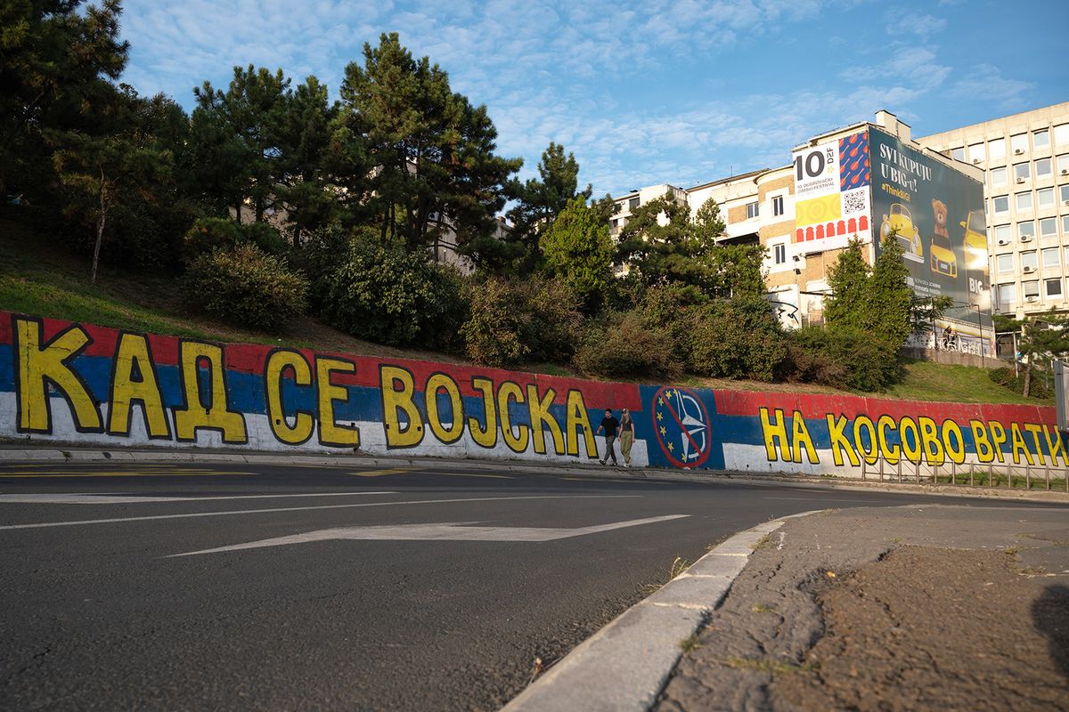 Pedestrians walk past a mural painted in colours of the Serbian flag, reading "When the Army returns to Kosovo…" in Belgrade on October 1, 2023. Nearly a week after deadly clashes in Kosovo which triggered one of the gravest escalations in the former breakaway province in years, the opportunity for reconciliation between ethnic Albanians and Serbs seemed as distant as ever. (Photo by Andrej ISAKOVIC / AFP)