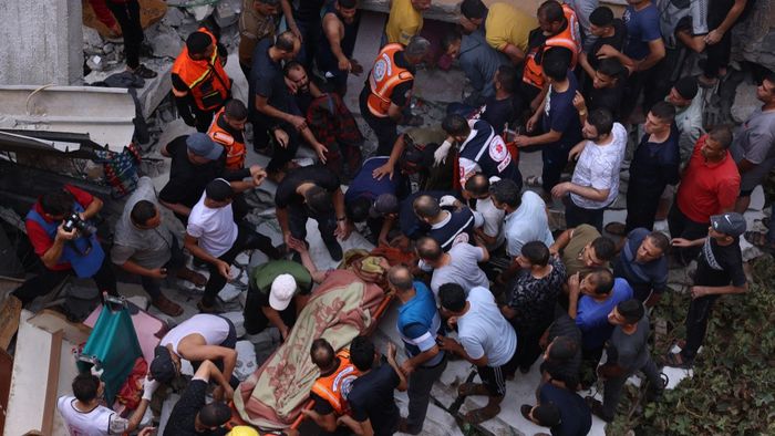 Rescuers remove people from under the rubble of a house destroyed by an Israeli air strike in Rafah in the southern Gaza Strip, on October 9, 2023. The Israeli army said it hit more than 500 targets in the Gaza Strip in overnight strikes, as the death toll from its war with Palestinian militants surged above 1,100. (Photo by SAID KHATIB / AFP)
