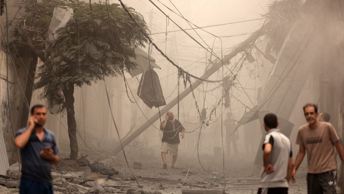 TOPSHOT - Palestinians inspect the destruction in a neighbourhood heavily damaged by Israeli airstrikes on Gaza City's Shati refugee camp early on October 9, 2023. The Israeli army said it hit more than 500 targets in the Gaza Strip in overnight strikes, as the death toll from its war with Palestinian militants surged above 1,100. (Photo by MAHMUD HAMS / AFP)