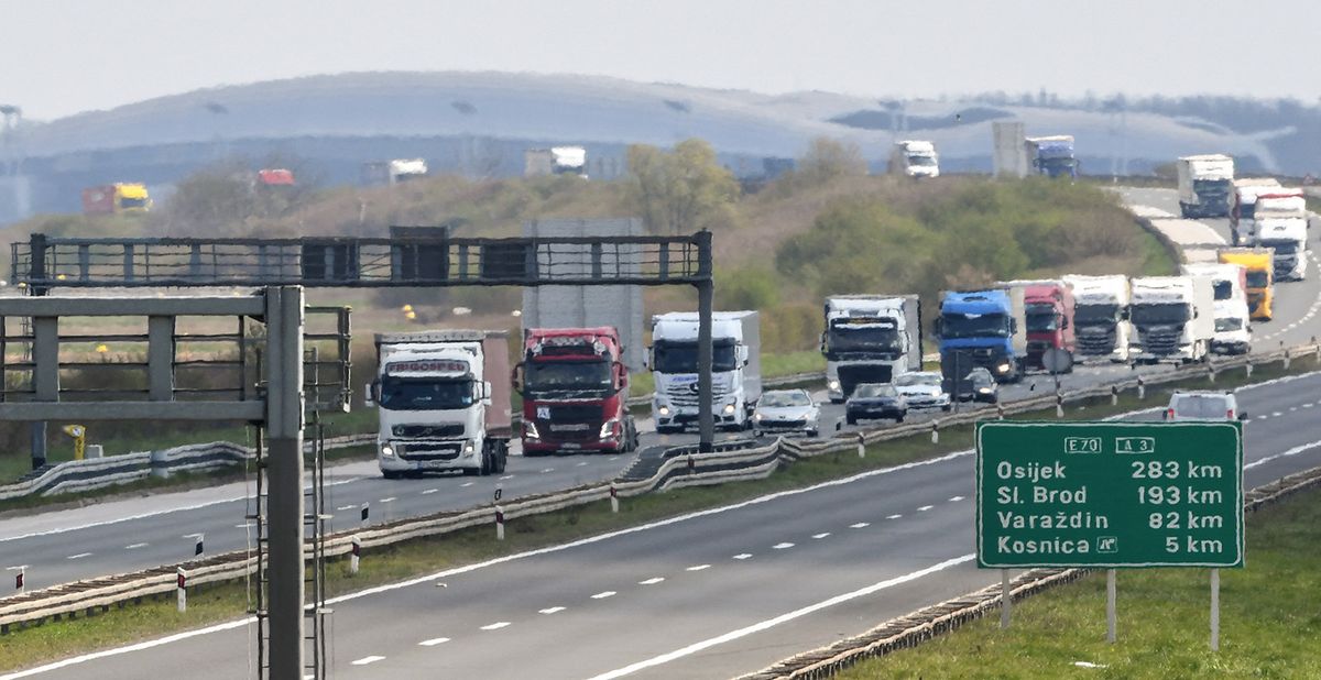 This general view shows a convoy of trucks, escorted by police authorities as they pass along the E70 highway on the outskirts of Zagreb on April 4, 2020. Transport of goods in Croatia has been organised into escorted convoys to ensure the safe provision of goods amid the spread of the novel coronavirus (COVID-19) in Croatia. (Photo by Denis LOVROVIC / AFP)
