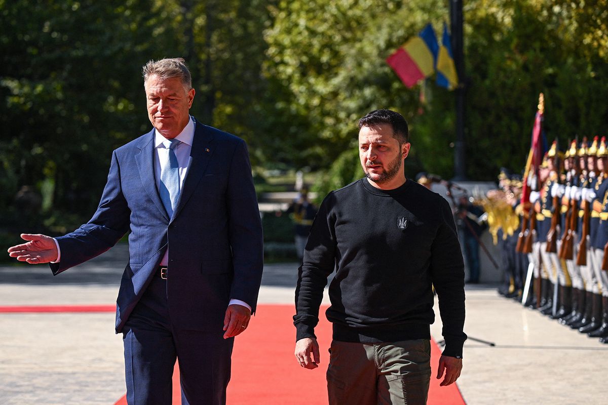 Ukrainian President Volodymyr Zelensky (R) and his Romanian counterpart Klaus Iohannis (L) review the honor guard during official welcoming ceremony at the Cotroceni Palace, the Romanian Presidency headquarters in Bucharest on October 10, 2023. (Photo by Daniel MIHAILESCU / AFP)