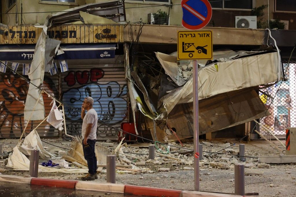 TOPSHOT - A man stands in front of a damaged shop in Tel Aviv, after it was hit by a rocket fired by Palestinian militants from the Gaza Strip on October 7, 2023. Palestinian militant group Hamas launched a surprise large-scale attack against Israel on October 7, firing thousands of rockets from Gaza and sending fighters to kill or abduct people as Israel retaliated with devastating air strikes. (Photo by JACK GUEZ / AFP)