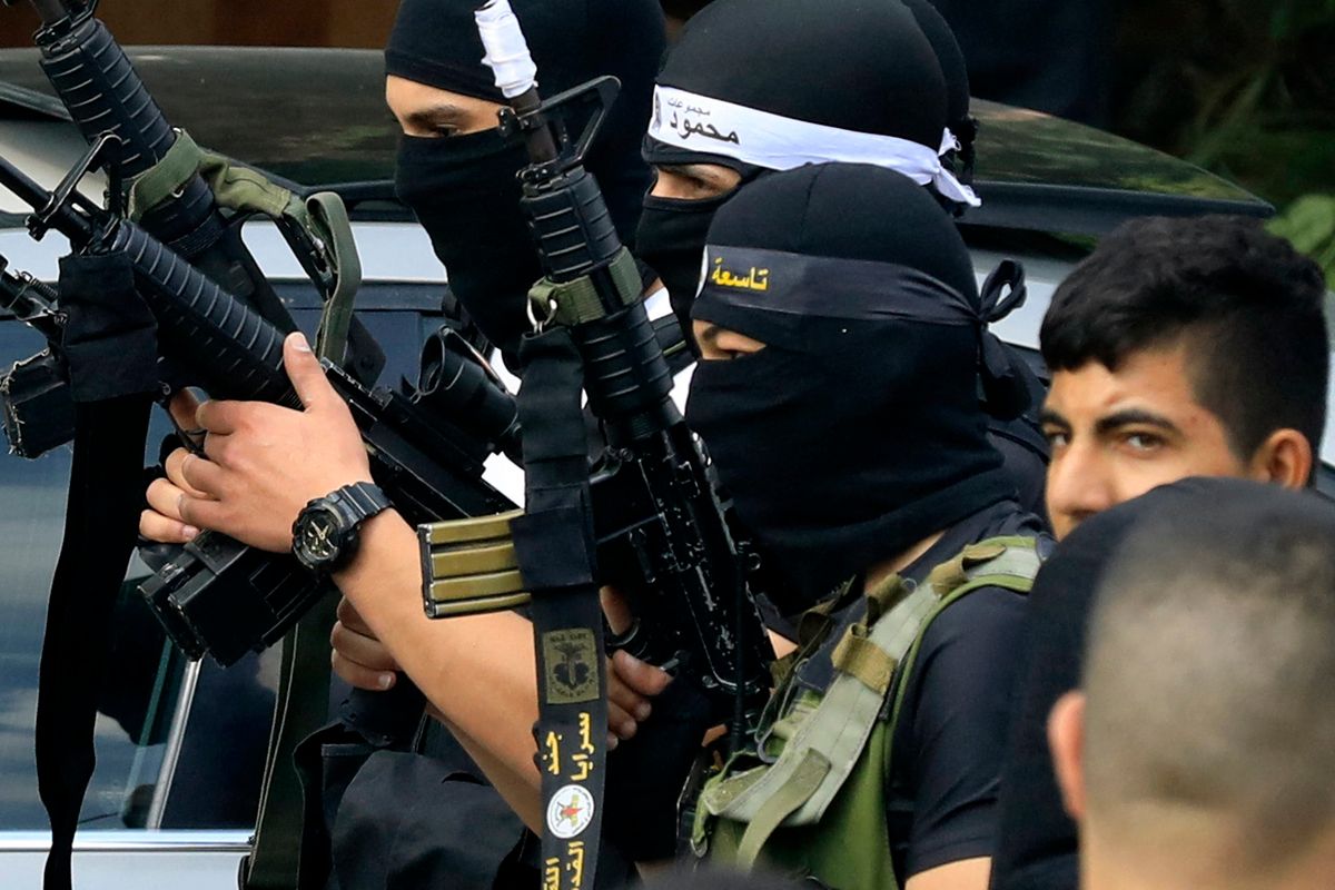 Palestinian gunmen attend the funeral of Ahmad 25, and Mahmud, 21, Sbaana, in the village of Qabatiyah, in the occupied West Bank, who were killed during clashes with Israeli forces at the al-Jalamah checkpoint overnight, on October 11, 2023. Israel declared war on Hamas on October 8 following a shock land, air and sea assault by the Gaza-based Islamists. The death toll from the shock cross-border assault by Hamas militants rose to 1,200, making it the deadliest attack in the country's 75-year history, while Gaza officials reported more than 900 people killed as Israel pounded the territory with air strikes. (Photo by Zain JAAFAR / AFP)