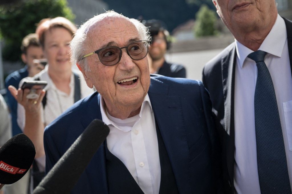 Former FIFA president Sepp Blatter, surrounded by journalists, arrives to Switzerland's Federal Criminal Court for listen the verdict of his trial over a suspected fraudulent payment, in the southern Switzerland city of Bellinzona, on July 8, 2022. The Bellinzona court will hand down its verdict in the trial of former UEFA president Michel Platini and former FIFA president Sepp Blatter. Blatter and Platini are being tried over a two-million-Swiss-franc ($2 million) payment in 2011 to the former France captain, who by that time was in charge of European football's governing body UEFA. (Photo by Fabrice COFFRINI / AFP)