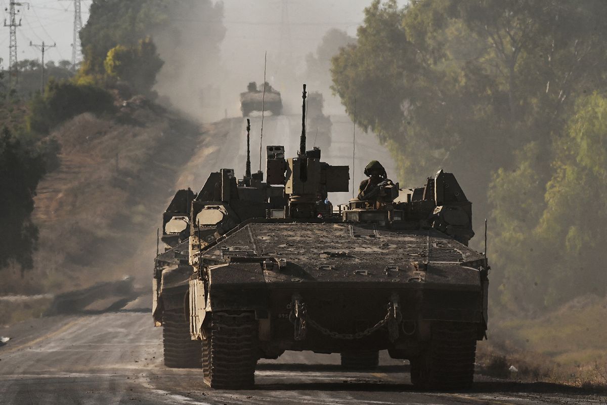 Israeli army armoured vehicles roll towards the border with the Gaza Strip at an undisclosed location in southern Israel on October 15, 2023. Thousands of people, both Israeli and Palestinians have died since October 7, 2023, after Palestinian Hamas militants based in the Gaza Strip, entered southern Israel in a surprise attack leading Israel to declare war on Hamas in Gaza the following day. (Photo by YURI CORTEZ / AFP)