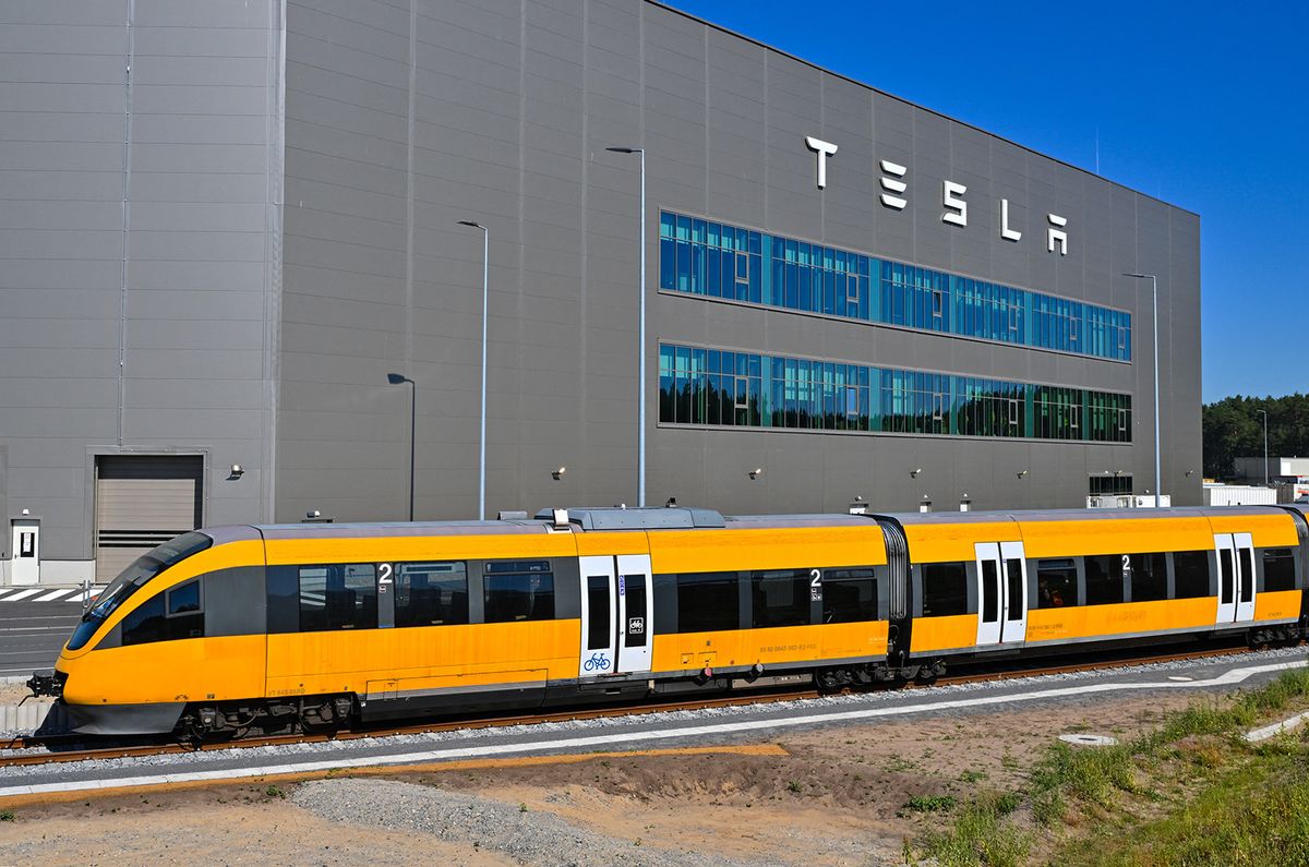 06 September 2023, Brandenburg, Grünheide: Tesla's new shuttle train travels to the station of the Tesla Gigafactory Berlin-Brandenburg. Since 04.09.2023, a Tesla shuttle train has been running to bring employees from Erkner station to the factory. The train does not fall under the law on incidents. An environmental association sees risks - unlike Tesla. The new factory shuttle train of electric car manufacturer Tesla does not have to meet any special safety requirements for a possible incident. The train between Erkner station near Berlin and the factory site in Grünheide, which started on Monday, is not subject to incident law. By contrast, the car plant, which was approved by the state of Brandenburg last year, must meet certain requirements to prevent or respond to a major accident. These include reporting and notification requirements. The environmental association Grüne Liga Brandenburg is concerned. Tesla, on the other hand, dismissed concerns. The train is not an incident-relevant facility because no corresponding substances are handled there, it says. Photo: Patrick Pleul/dpa (Photo by PATRICK PLEUL / DPA / dpa Picture-Alliance via AFP)