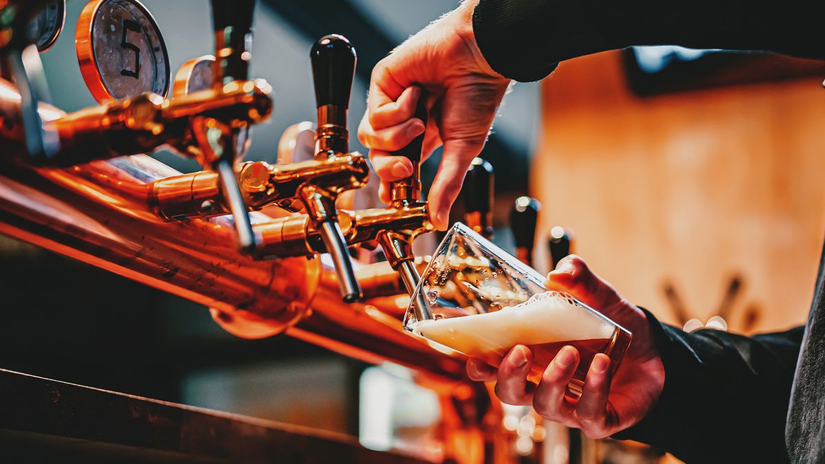 Bartender,Hand,At,Beer,Tap,Pouring,A,Draught,Beer,Inbartender hand at beer tap pouring a draught beer in glass serving in a bar or pub, sörcsap, dreher,