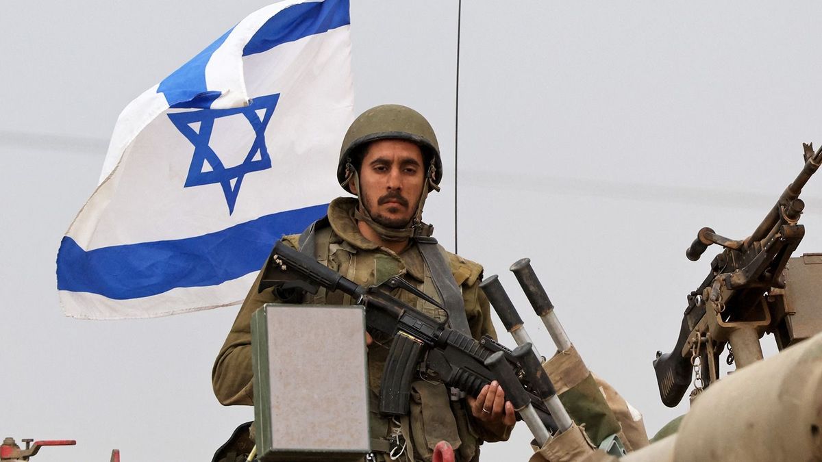 An Israeli soldier rides on an armoured vehicle as the army takes positions in their armoured vehicles near the border with Gaza in southern Israel on October 9, 2023. Stunned by the unprecedented assault on its territory, a grieving Israel has counted over 700 dead and launched a withering barrage of strikes on Gaza that have raised the death toll there to 493 according to Palestinian officials. (Photo by JACK GUEZ / AFP)