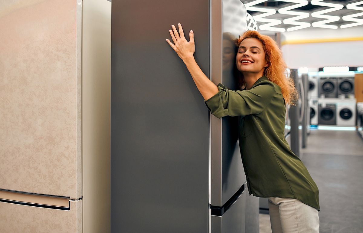 Beautiful,Red-haired,Woman,Hugging,A,Refrigerator,In,A,Home,Appliances