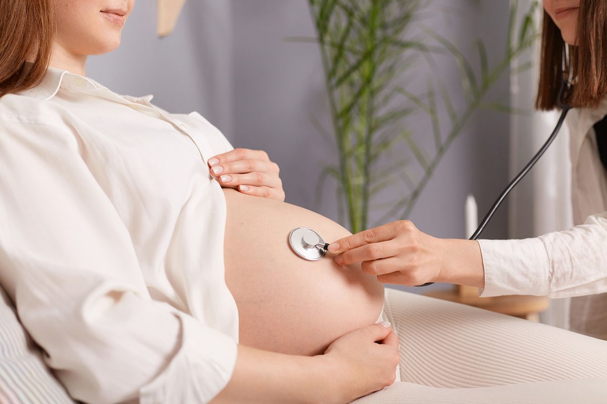 Unrecognizable,Pregnant,Female,With,Bare,Belly,And,Stethoscope,Doctor,Listening