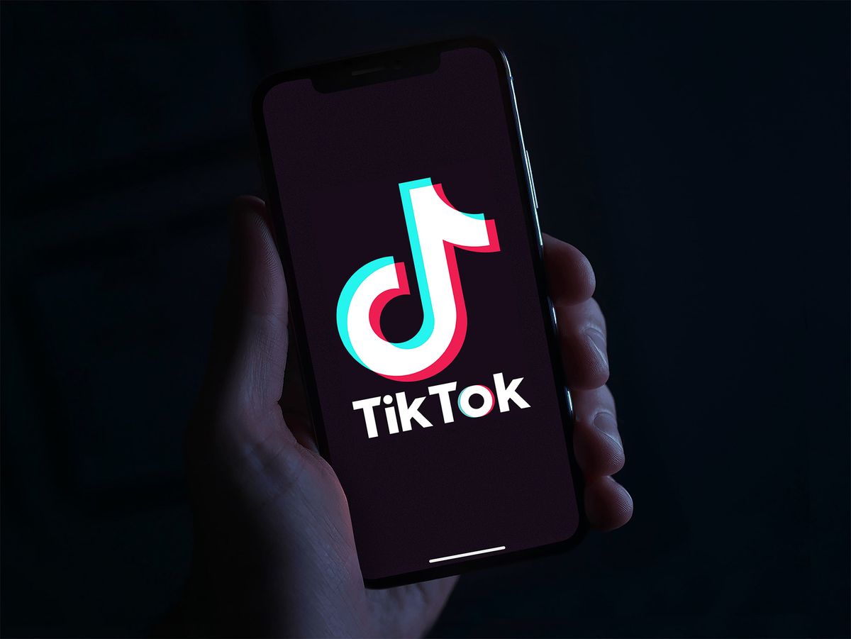 Hand,Holding,Phone,With,The,Tiktok,Logo,In,Front,Of