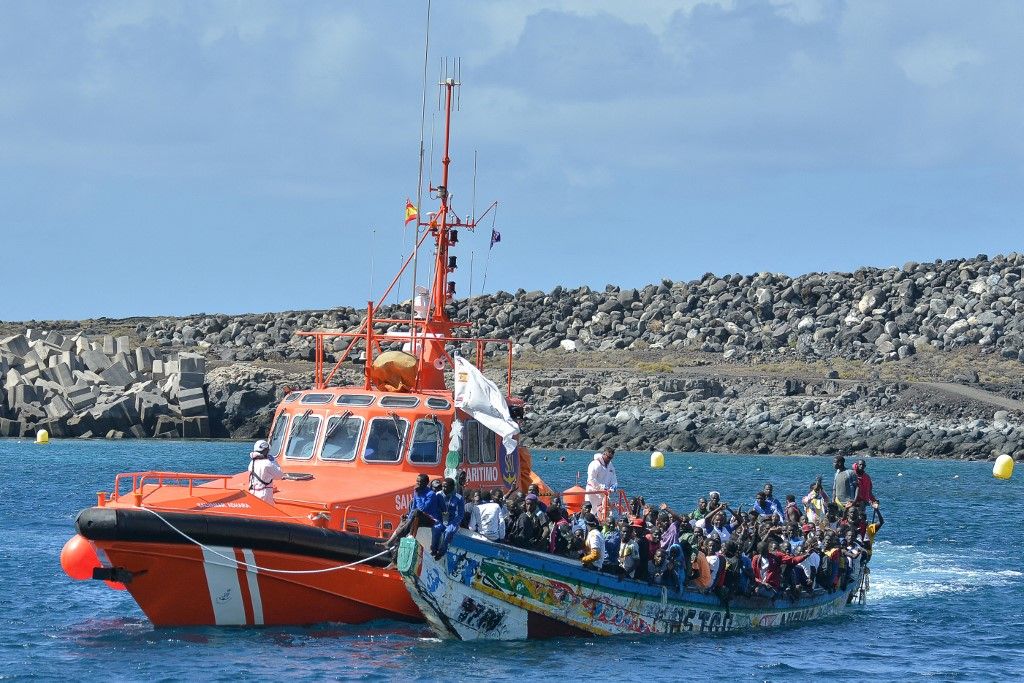 Spanish Sea Rescue vessel "Salvamar Adhara" accost a boat carrying migrants at La Restinga dock, in the municipality of El Pinar on the Canary Island of El Hierro, on October 21, 2023. More than 1,300 African migrants have reached Spain's Canary Islands this weekend, with one vessel bringing a single-boat record of 321 people, authorities said on October 22. October 21 saw 321 people reach the island of El Hierro aboard one vessel, a rescue services spokesperson told AFP, surpassing the previous record for a single boat of 280 on October 3. (Photo by STRINGER / AFP)
