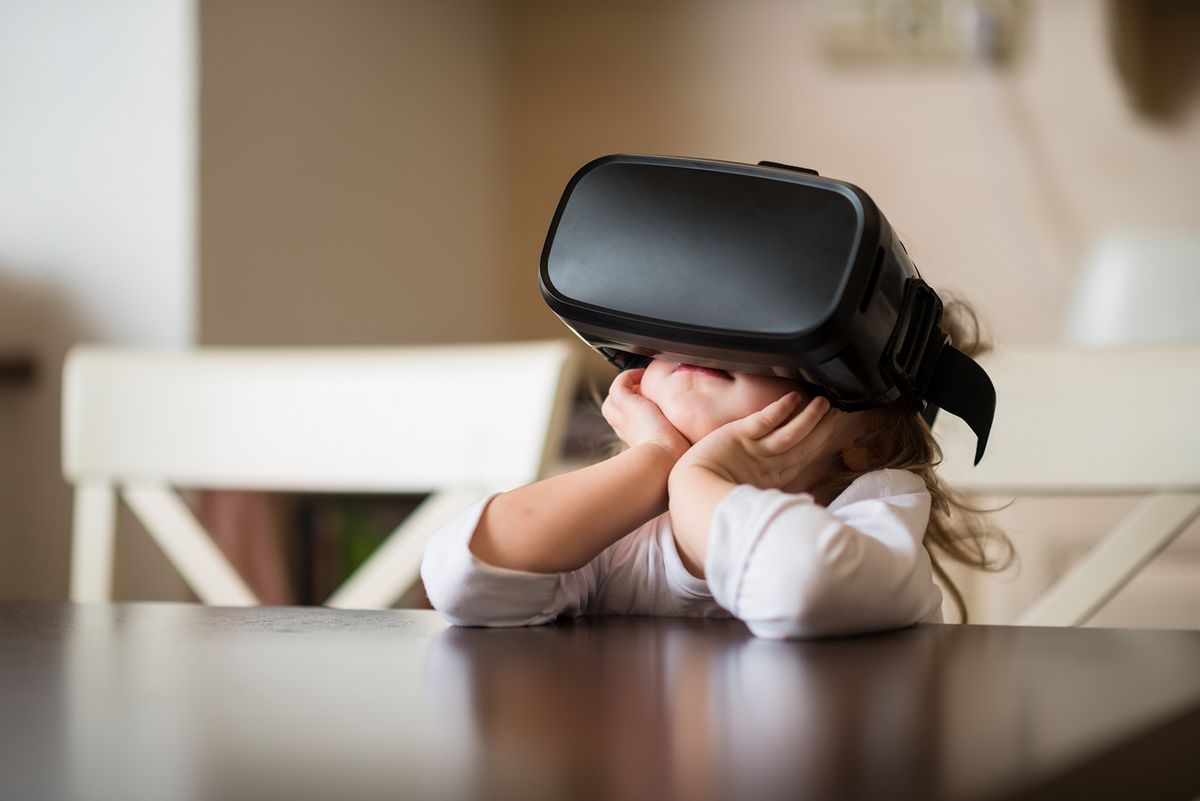 Child,With,Virtual,Reality,Headset,Sitting,Behind,Table,Indoors,At
