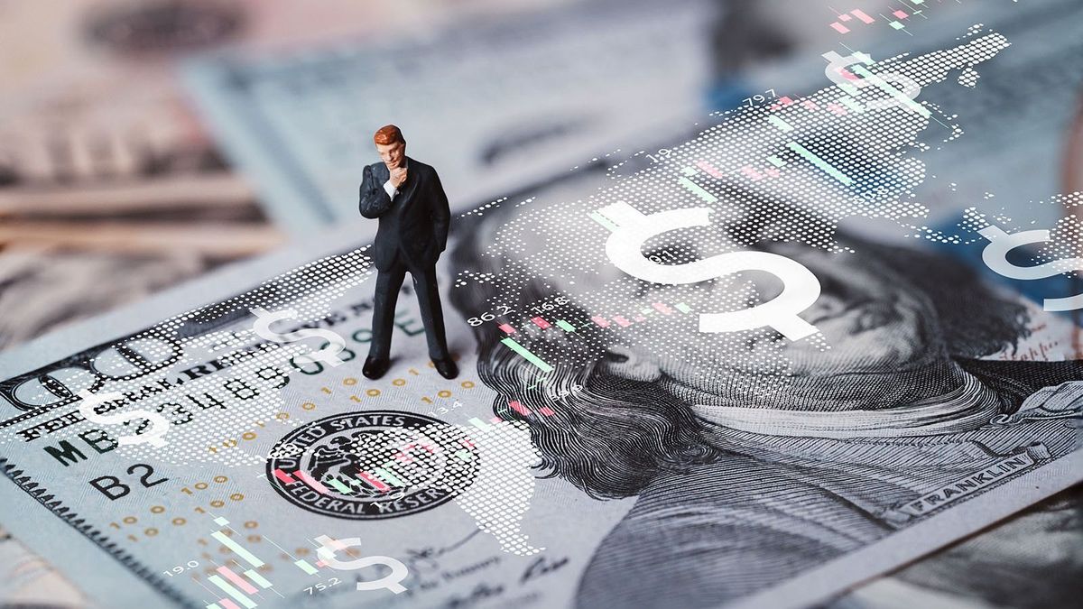 Businessman,Miniature,Figure,Standing,On,Usd,Banknote,With,Stock,Market