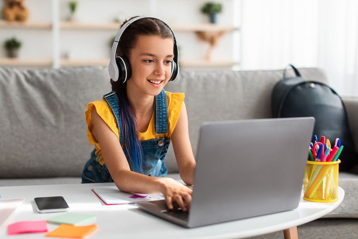 Portrait,Of,Little,Girl,In,Wireless,Headset,Using,Laptop,,Studying