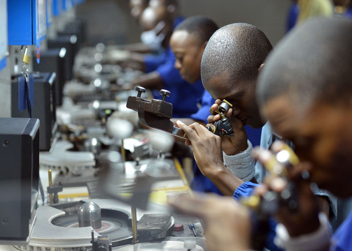 Workers check, cut and polish diamonds at a Diamond cutting and polishing company during the tour by Ghanian President John Dramani Mahama in Gaborone, on March 11, 2015. AFP PHOTO/MONIRUL BHUIYAN (Photo by Monirul Bhuiyan / AFP)