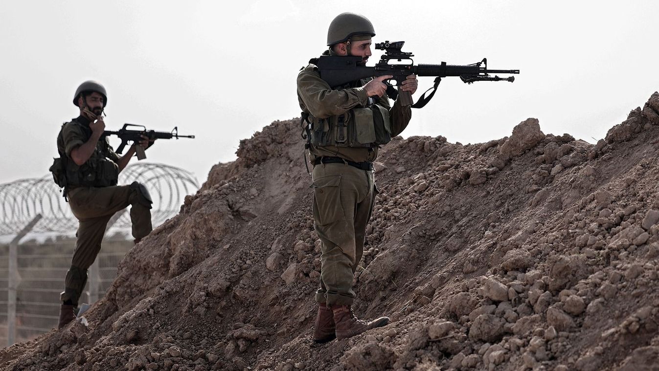 In this picture taken during a media tour organised by the Israeli military on October 22, 2023, Israeli soldiers take a defensive position in Kibbutz Beeri along the border with the Gaza Strip, in the aftermath of a Palestinian militant attack on October 7. (Photo by Thomas COEX / AFP)