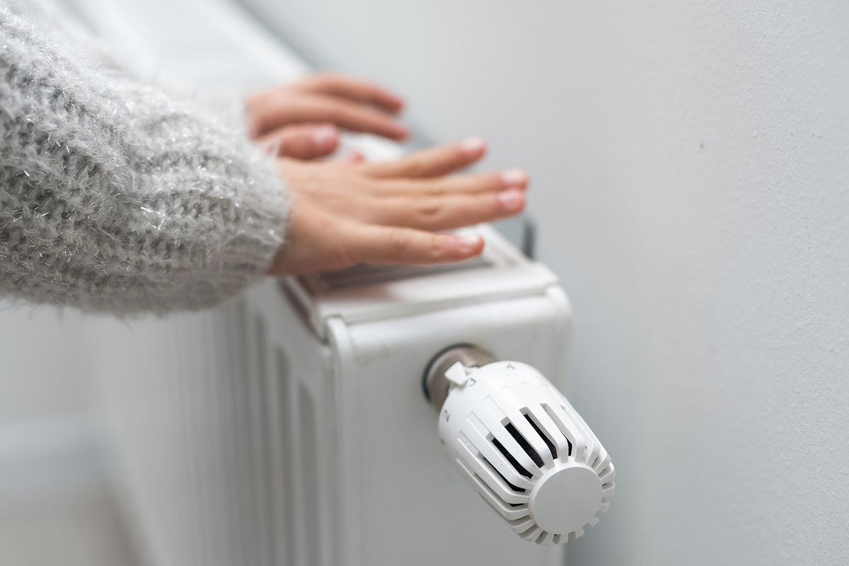 The,Child's,Hands,Warm,Their,Hands,Near,The,Heating,Radiator.