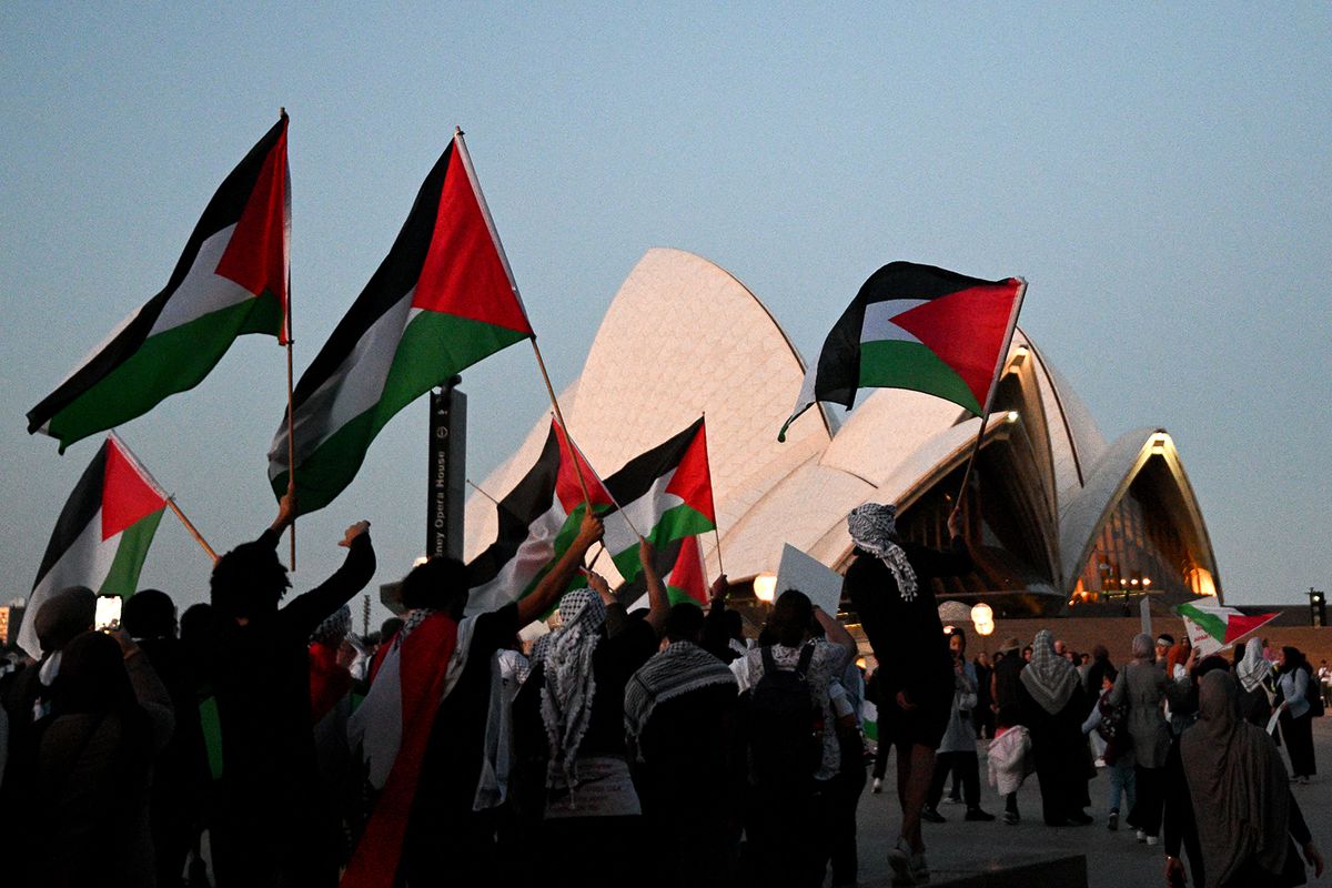 Protesters show their support for Palestinians during a rally in front of the Opera House in Sydney on October 9, 2023. Israel relentlessly pounded the Gaza Strip overnight and into October 9 as fighting with Hamas continued around the Gaza Strip, as the death toll from the war against the Palestinian militants surged above 1,100. (Photo by Izhar KHAN / AFP)