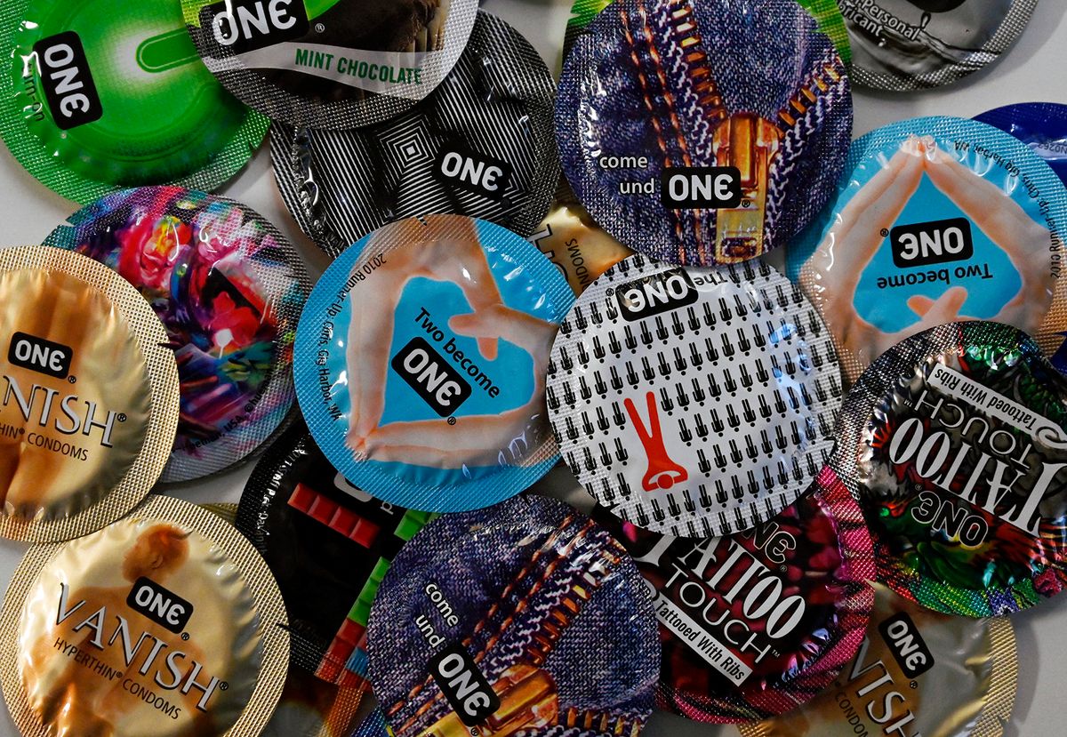 This illustration photo shows "One" condoms displayed on a table in Washington, DC, on February 23, 2022. The US Food and Drug Administration (FDA) has authorized the first condom for use during anal intercourse, in what was hailed as a victory for sexual health by experts. (Photo by OLIVIER DOULIERY / AFP)