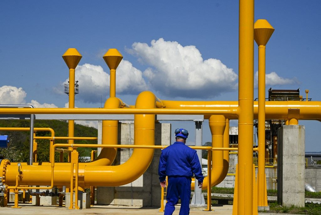 A employee works near gas pipes at the gas compressor station of Bulgartransgaz in Ihtiman, on May 5, 2022, a week after the halt of Russian gas supply to Bulgaria. The halt of Russian gas has left companies -- big and small -- scrambling as they fear insecure deliveries and rising prices. Since its invasion of Ukraine soured its international relations, Moscow insists Gazprom customers must pay in rubles rather than US dollars or euros, leading the Russian energy giant to cut deliveries to Bulgaria and Poland on April 27. (Photo by Nikolay DOYCHINOV / AFP)