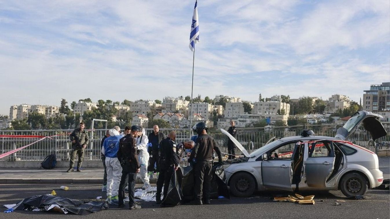 Israeli police and security forces stand next to the covered bodies of suspected attackers as they secure the site of a shooting in Jerusalem on November 30, 2023. (Photo by Menahem KAHANA / AFP)