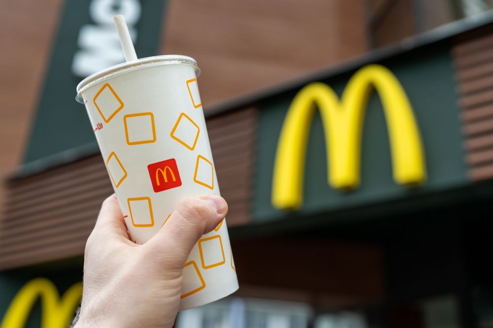 Mcdonald's,Soft,Drink,In,Hand,Against,The,Background,Of,A