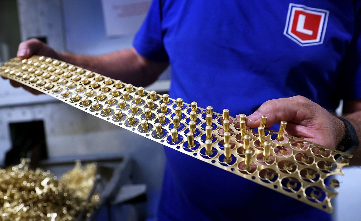 An employee checks stamped brass cartridge cases at the Lapua rimfire production factory (Nammo Corporation) on July 12, 2021 in Schoenebeck near Magdeburg, eastern Germany. For the French Biathlon team, the Winter Olympics are being prepared in the heart of summer, in a German munitions factory steeped in history, where a cold room recreates the freezing temperatures of the competitions. (Photo by Ronny Hartmann / AFP)
