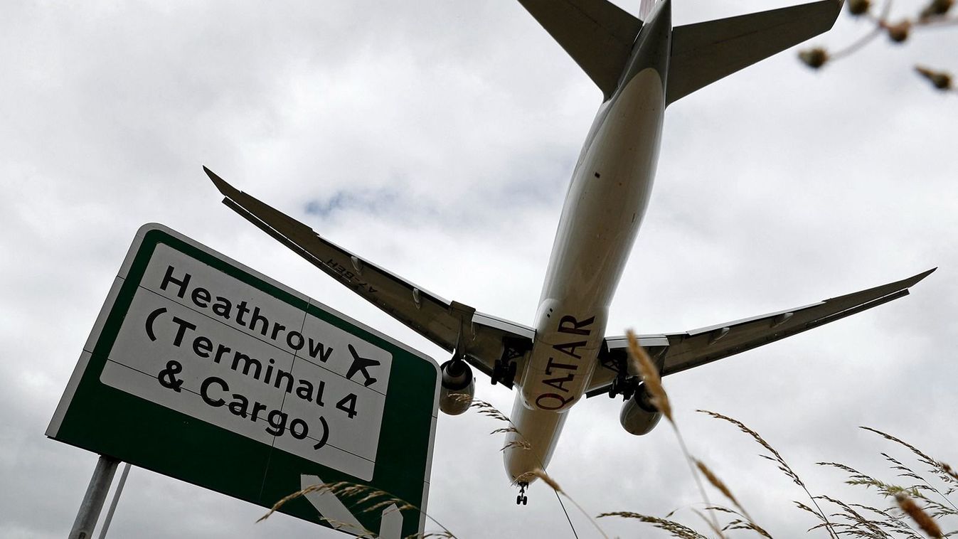 (FILES) A Qatar Airways flight pases above a road sign as it prepares to land at Heathrow airport in west London on June 8, 2020. Spanish infrastructure giant Ferrovial announced it is offloading its remaining 25 percent stake in London's Heathrow Airport to a French private equity group and Saudi Arabia's sovereign wealth fund. After owning the UK travel hub for 17 years, Ferrovial said on November 29, 2023, it had reached a 2.37 billion pound ($3.01 billion) deal with Paris-based Ardian and Riyahd's Public Investment Fund (PIF). (Photo by Adrian DENNIS / AFP)