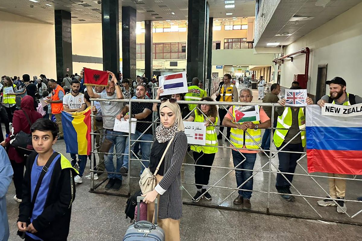 Representatives from various embassies wait for dual nationals arriving in the Egyptian part of the Rafah border crossing with the Gaza Strip on November 12, 2023, after fleeing the Palestinian enclave due to the ongoing battles between Israel and the militant group Hamas. (Photo by AFP)