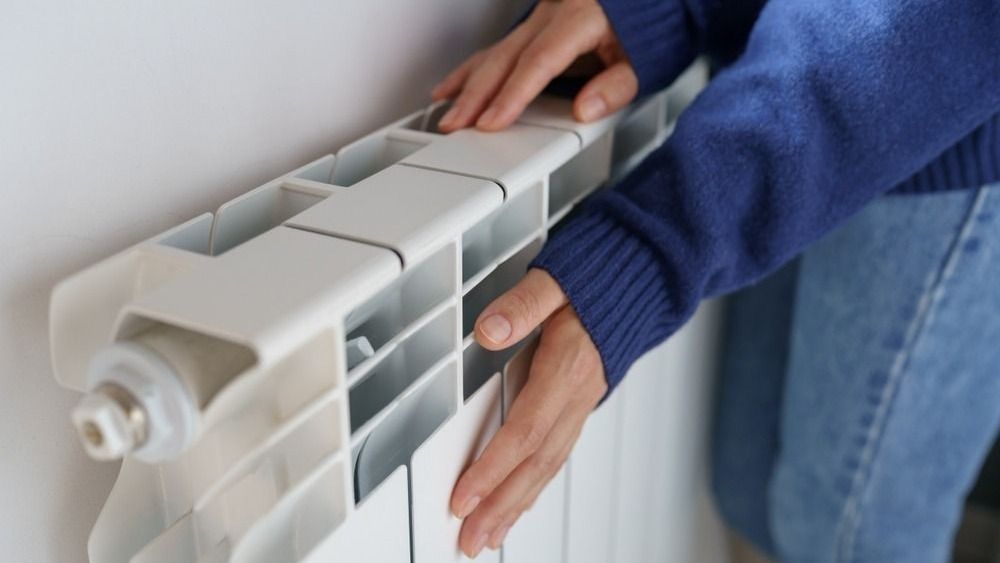 Closeup,Of,Woman,Warming,Her,Hands,On,The,Heater,At