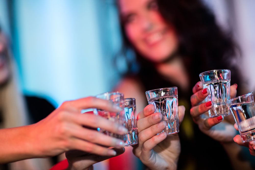 Group,Of,Friends,Toasting,Tequila,Shot,Glasses,In,Bar