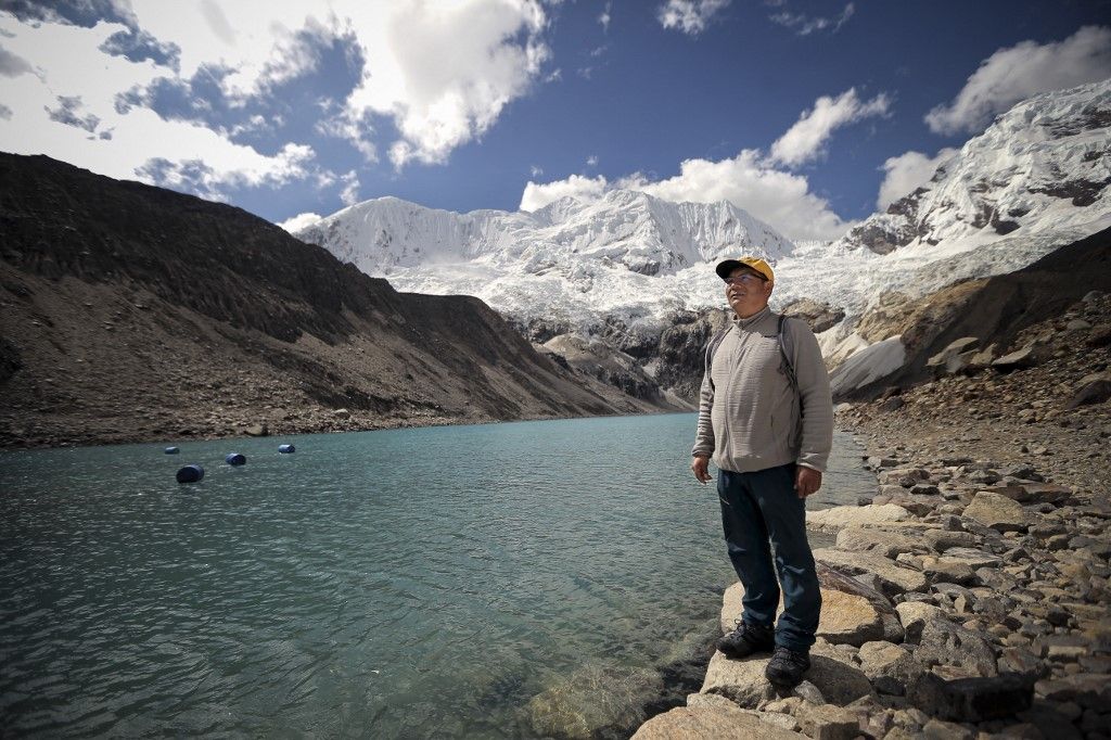 Saul Luciano Lliuya, 41, poses for a photo in front of the Palcacocha Lake, located at 4,650 meters above sea level at the Huascaran National Park, in Huaraz, northeastern Peru, on May 23, 2022. Lliuya, a farmer and tourist guide of the Cordillera Blanca of the Peruvian Andes, is carrying out a legal battle so that German energy giant RWE is declared by the German justice responsible for the melting of the Peruvian glaciers, for its emissions of greenhouse gases. (Photo by Luka GONZALES / AFP)