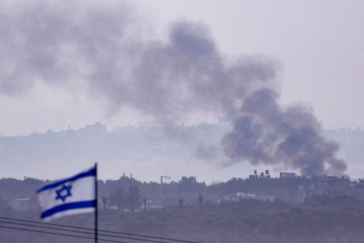 This picture taken from the Israeli side of the border with the Gaza Strip on November 11, 2023, shows smoke rising over buildings during an Israeli strike on the Palestinian enclave, amid ongoing battles between Israel and the Palestinian Hamas movement. (Photo by Kenzo TRIBOUILLARD / AFP)