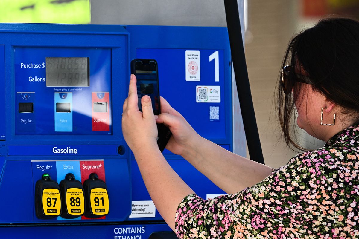 A customer photographs a gas pump after fueling up at a station with prices above average at over seven dollars a gallon at a Mobil gas station in Los Angeles, California, on October 5, 2023. Oil prices tumbled further following their September surge after a US report on gasoline inventories came in much higher than analysts expected, an indication of weakening demand in the world's largest economy. (Photo by Patrick T. Fallon / AFP)