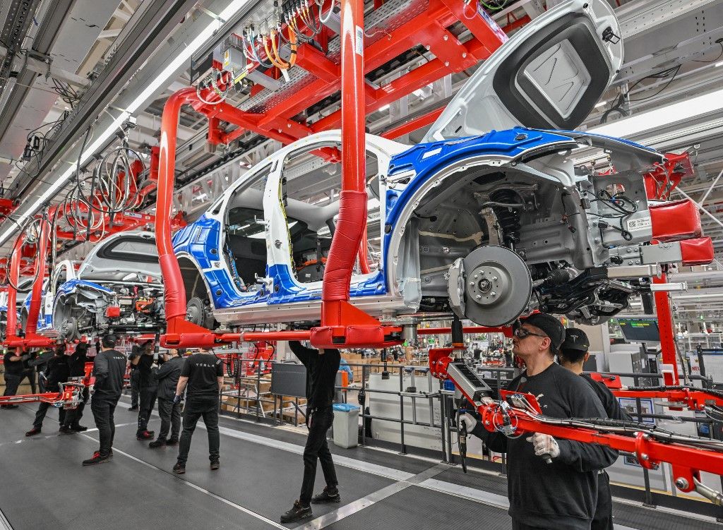 One year Tesla Gigafactory Berlin Brandenburg20 March 2023, Brandenburg, Grünheide: Employees of the Tesla Gigafactory Berlin Brandenburg work on a production line of a Model Y electric vehicle. The Tesla plant was opened and put into operation on March 22, 2022. In the meantime, about 10,000 people are employed there. (to dpa "One year of Tesla plant in Germany - showcase factory and object of dispute") Photo: Patrick Pleul/dpa (Photo by PATRICK PLEUL / DPA / dpa Picture-Alliance via AFP)