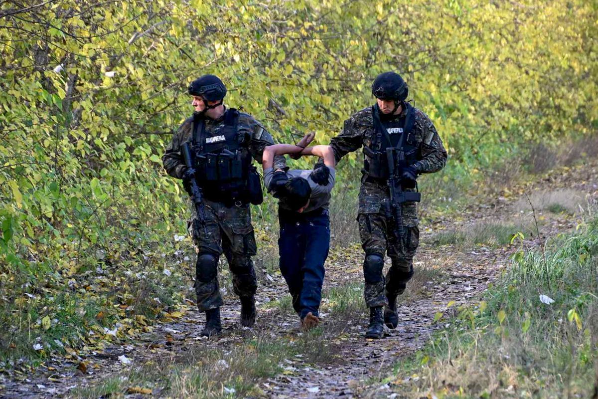 Horgos, 2023. október 30.
A szerb belügyminisztérium által közreadott felvételen szerb rendőrök elvezetnek egy őrizetbe vett migráns férfit a magyar határnál levő Horgosnál 2023. október 29-én. A szerbiai hatóságok több száz rendőrt vezényeltek a Magyarországgal közös határszakaszra azt követően, hogy október 27-én hajnalban lövöldözés tört ki migránsok között Horgosnál. A három halálos áldozatot követelő incidenssel összefüggésben hat migránst állítottak elő, négyen afgán, ketten török állampolgárnak vallották magukat. A szerb-magyar határ mentén több ezer migráns vár arra, hogy átszökhessen az Európai Unióba.
MTI/AP/Szerb belügyminisztériumHorgos, 2023. október 30.
A szerb belügyminisztérium által közreadott felvételen szerb rendőrök elvezetnek egy őrizetbe vett migráns férfit a magyar határnál levő Horgosnál 2023. október 29-én. A szerbiai hatóságok több száz rendőrt vezényeltek a Magyarországgal közös határszakaszra azt követően, hogy október 27-én hajnalban lövöldözés tört ki migránsok között Horgosnál. A három halálos áldozatot követelő incidenssel összefüggésben hat migránst állítottak elő, négyen afgán, ketten török állampolgárnak vallották magukat. A szerb-magyar határ mentén több ezer migráns vár arra, hogy átszökhessen az Európai Unióba.
MTI/AP/Szerb belügyminisztériumHorgos, 2023. október 30.A szerb belügyminisztérium által közreadott felvételen szerb rendőrök elvezetnek egy őrizetbe vett migráns férfit a magyar határnál levő Horgosnál 2023. október 29-én. A szerbiai hatóságok több száz rendőrt vezényeltek a Magyarországgal közös határszakaszra azt követően, hogy október 27-én hajnalban lövöldözés tört ki migránsok között Horgosnál. A három halálos áldozatot követelő incidenssel összefüggésben hat migránst állítottak elő, négyen afgán, ketten török állampolgárnak vallották magukat. A szerb-magyar határ mentén több ezer migráns vár arra, hogy átszökhessen az Európai Unióba.MTI/AP/Szerb belügyminisztérium
