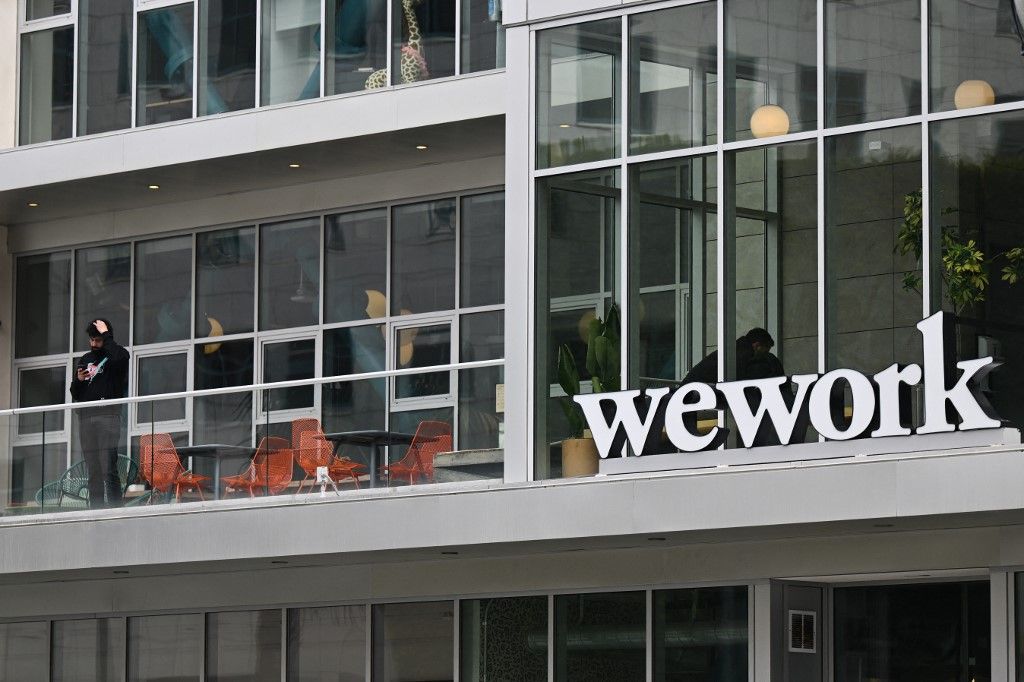 The WeWork logo is displayed outside of an office space rental location in Santa Monica, California on March 20, 2023. (Photo by Patrick T. Fallon / AFP)