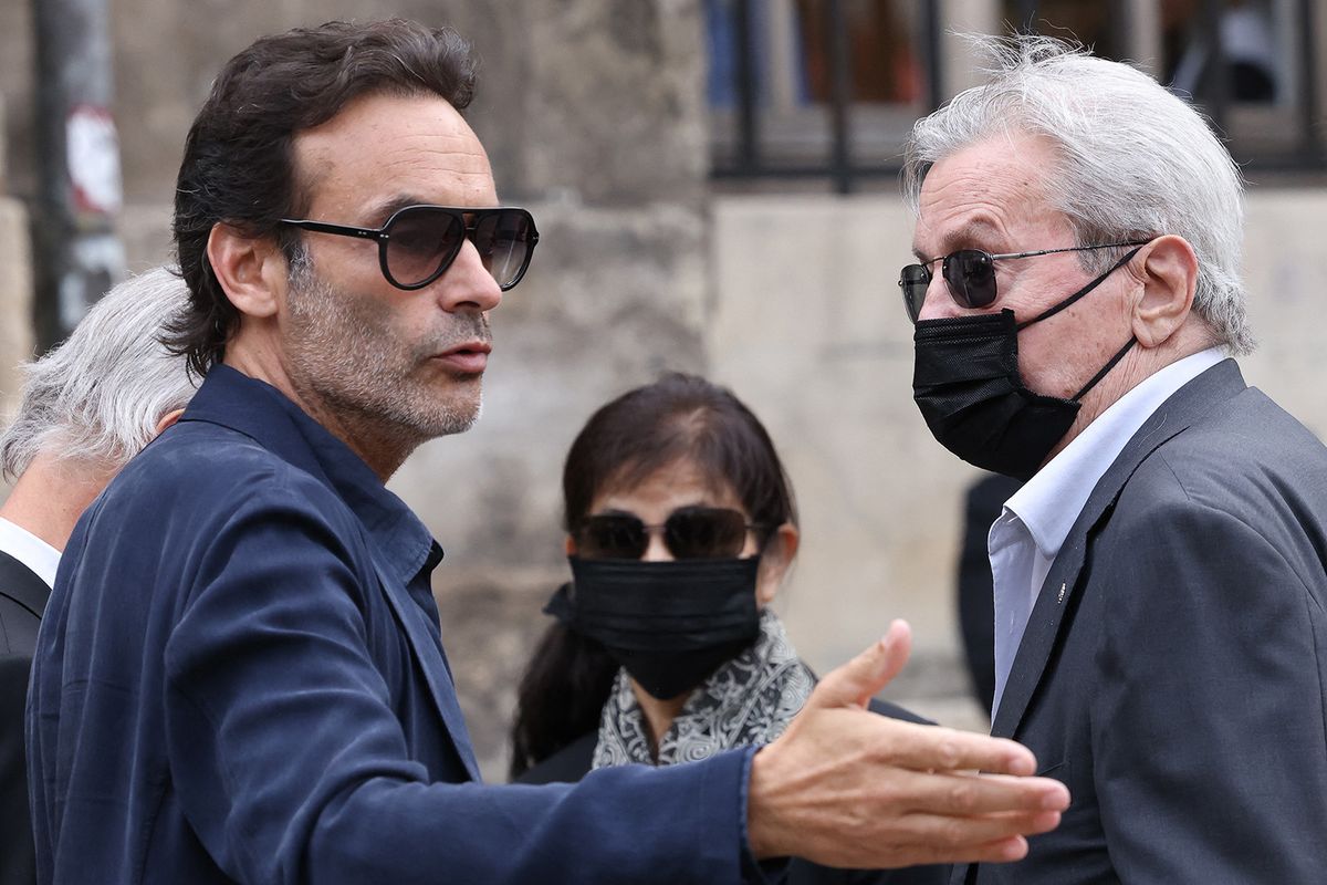 French actor Alain Delon (R), his partner and assistant Hiromi Rollin (C) and his son Anthony Delon arrive for the funeral ceremony for late French actor Jean-Paul Belmondo at the Saint-Germain-des-Pres church in Paris on September 10, 2021. Several hundred of attendees have gathered to pay their respects to one of the most popular French actors on September 9, 2021: his relatives, the French President and members of the government as well as personalities from the world of cinema, culture and sport. Belmondo died on September 6, 2021 aged 88. (Photo by Thomas COEX / AFP)