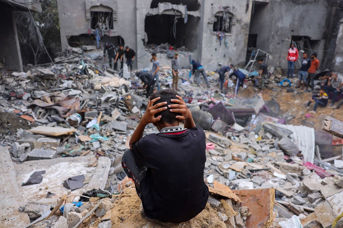 A child reacts as people salvage belongings amid the rubble of a damaged building following strikes on Rafah in the southern Gaza Strip, on November 12, 2023, as battles between Israel and the Palestinian Hamas movement continue. More than 10,000 people have been killed in relentless Israeli bombardment of the Gaza Strip, according to the Hamas-run health ministry, since the war erupted last month after Palestinian militants raided southern Israel on October 7 killing at least 1200 people. (Photo by Mohammed ABED / AFP)