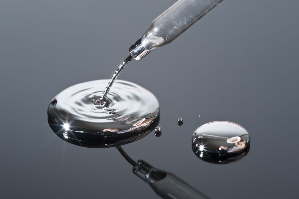 Mercury,Pouring,From,A,Pipette,Onto,A,Reflective,Surface