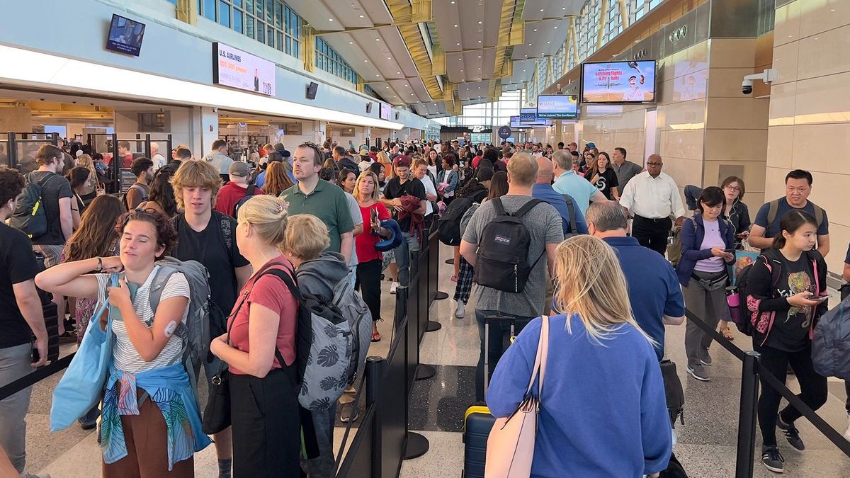 Travelers wait in line to go through security at Ronald Reagan Washington National Airport (DCA) in Arlington, Virginia, on July 23, 2023. (Photo by Daniel SLIM / AFP) hálaadás