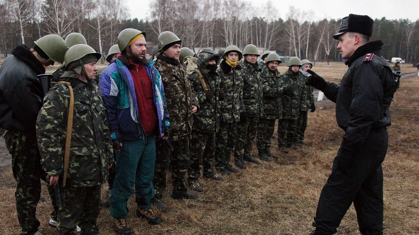 A Ukrainian interim forces officer (R) talks to recruits during their exercises not far from Kiev on March 17, 2014. Ukraine's parliament on March 17 approved the partial mobilisation of troops to counter "Russian interference" on its soil, a day after Crimea voted to secede from Kiev and join Russia. Ahead of March 16 referendum, Kiev had called last week for the initial mobilisation of reservists and approved the creation of a new National Guard of 60,000 volunteers, as Russian forces encircled Ukrainian military bases in Crimea.  AFP PHOTO / ANATOLII STEPANOV (Photo by ANATOLII STEPANOV / AFP)