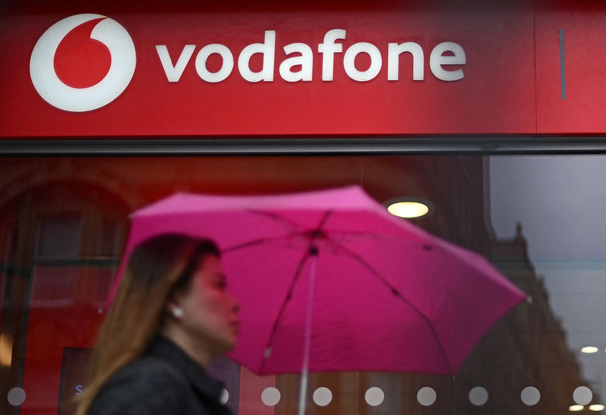A pedestrian passes a Vodafone store in west London on May 15, 2022. (Photo by Daniel LEAL / AFP)
