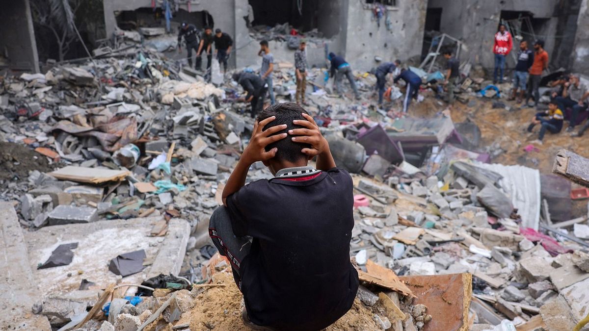 A child reacts as people salvage belongings amid the rubble of a damaged building following strikes on Rafah in the southern Gaza Strip, on November 12, 2023, as battles between Israel and the Palestinian Hamas movement continue. More than 10,000 people have been killed in relentless Israeli bombardment of the Gaza Strip, according to the Hamas-run health ministry, since the war erupted last month after Palestinian militants raided southern Israel on October 7 killing at least 1200 people. (Photo by Mohammed ABED / AFP)