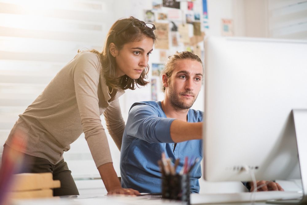 Two,Young,Colleagues,Working,On,A,Project,On,Computer