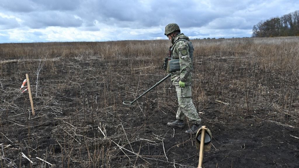 A deminer of Ukrainian national police searches mines in a field in Izyum district, Kharkiv region on October 24, 2023, amid the Russian invasion of Ukraine. (Photo by SERGEY BOBOK / AFP)